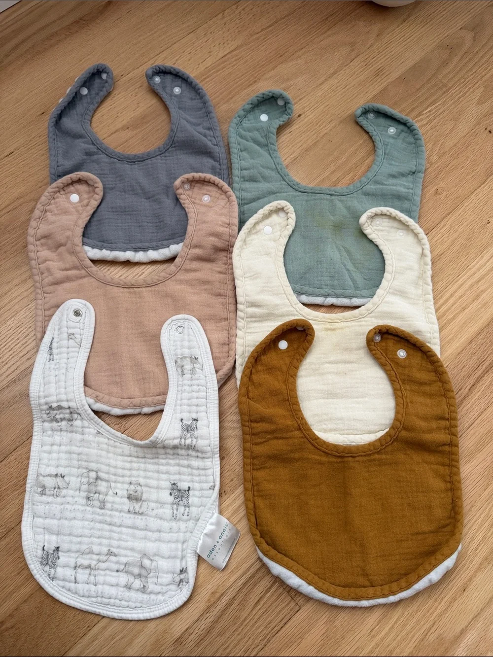 Bundle of muslin baby bibs in earthy colors